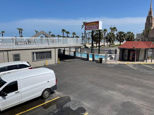 a white van parked in a parking lot next to a building at Budget Inn and Suites Corpus Christi in Corpus Christi