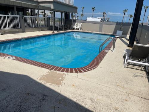 a large blue swimming pool in a building at Budget Inn and Suites Corpus Christi in Corpus Christi