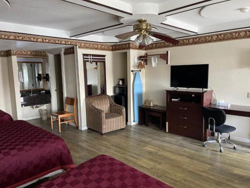 a hotel room with a bed and a flat screen tv at Budget Inn and Suites Corpus Christi in Corpus Christi