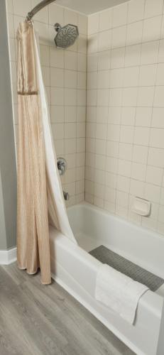 une salle de bain avec une baignoire et un rideau de douche dans l'établissement Oceanview Studio, à Daytona Beach