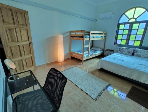 una camera con letto, tavolo e sedia di IKHSHANA NATURE HILLSIDE HOME a Kuah