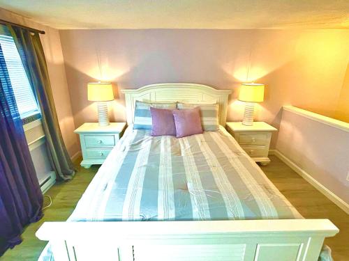 a bedroom with a white bed with two lamps at Portside Tavern in Hyannis