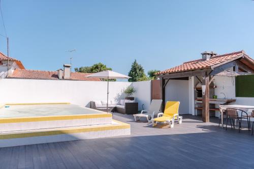a patio with a bed and a table and chairs at Retiro da Atafona Beach Pool House White in Monte