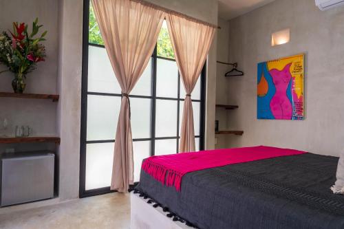 a bedroom with a bed and a large window at Turquoise Tulum Hotel in Tulum