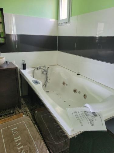une salle de bain avec baignoire dans une chambre dans l'établissement Cabanès des Aresquiers, à Frontignan