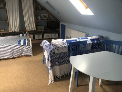 um quarto com uma mesa e uma cama e uma mesa e cadeiras em Porthcawl, Nr Sea & Centre. Private guest suite. em Porthcawl
