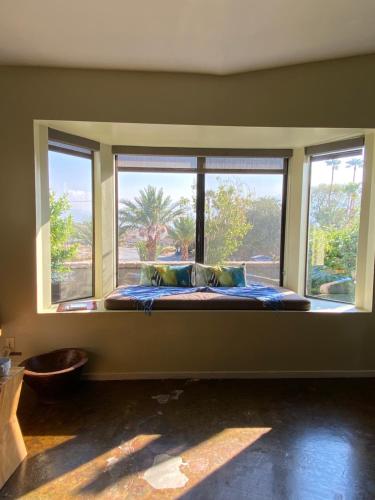 einen Fensterplatz in einem Zimmer mit einem Bett und zwei Fenstern in der Unterkunft The Spring Resort & Spa in Desert Hot Springs