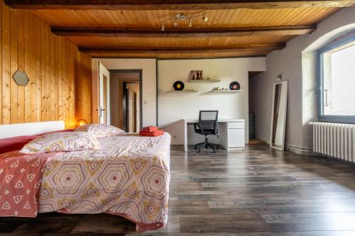 a bedroom with a bed and a desk in a room at Domaine du Chypre in Cercier