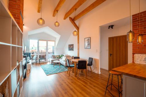 een keuken en een woonkamer met een tafel en stoelen bij Modlnica Wierzbowa Cosy Apartment in Krakau