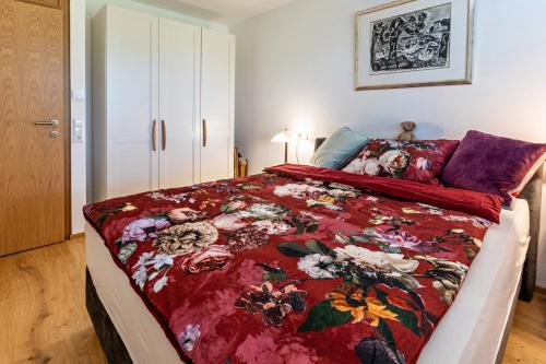 a bedroom with a bed with a red floral bedspread at Willhelm - Hauff in Engen
