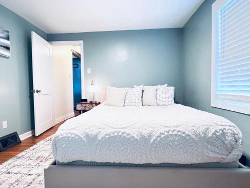 1 dormitorio con 1 cama grande y pared azul en Lakewoods Cottage, en Clintondale