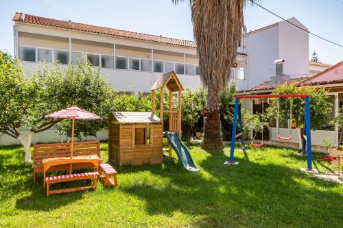 a yard with a playground and a house at Konstantina Apartments in Kavos