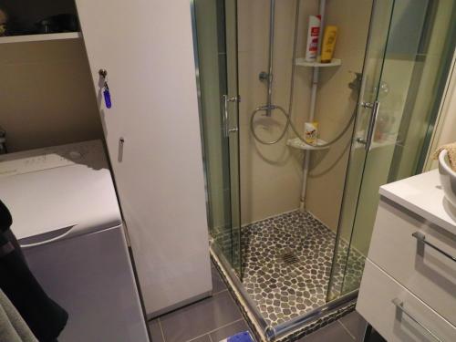 une douche avec une porte vitrée dans une salle de bain dans l'établissement Studio cabine climatisé avec terrasse, piscine et parking privé - FR-1-472A-140, à Sète