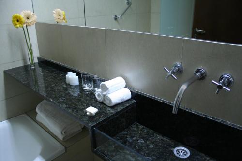 a bathroom with a counter with a sink and a mirror at Gran Hotel Argentino in Buenos Aires