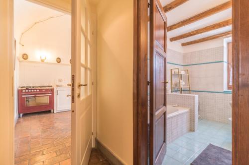 a kitchen with a door open to a bathroom with a tub at Casa Elfriede in Bolsena