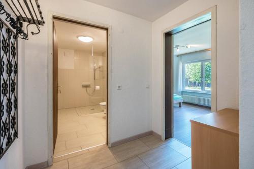 a bathroom with a shower and a door to a room at Haus Isele in Urberg