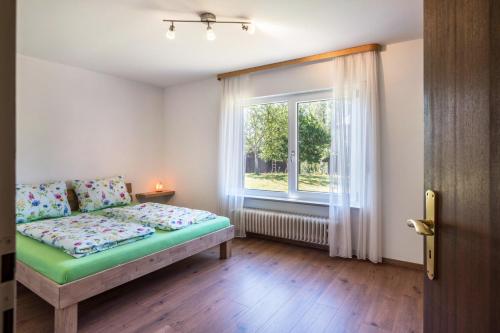 a bedroom with a bed and a window at Haus Isele in Urberg