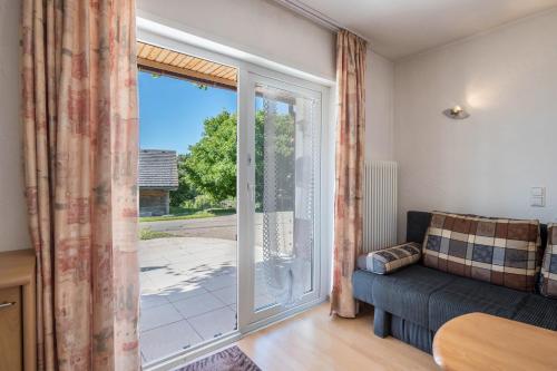 sala de estar con sofá y puerta corredera de cristal en Haus Isele, en Urberg