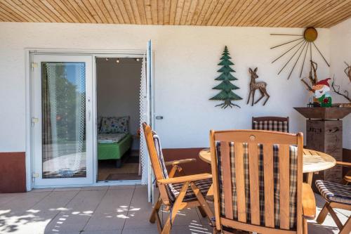 a dining room with a table and a christmas tree on the wall at Haus Isele in Urberg