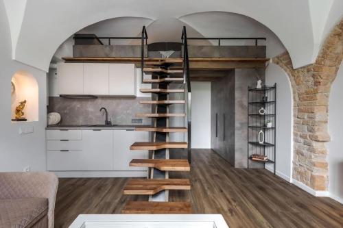 a kitchen with a spiral staircase in a room at Cozy Carmelite apartment in Vilnius