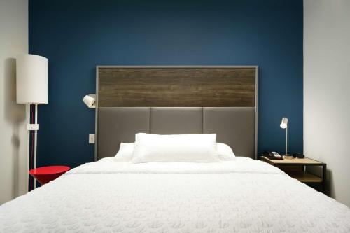 a bedroom with a large white bed with a blue wall at Tru By Hilton Chattanooga Hamilton Place, Tn in Chattanooga