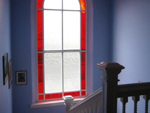 eine Treppe mit einem roten und weißen Fenster in einem Zimmer in der Unterkunft Dorstan House in Edinburgh