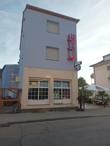 a white building with a sign on the side of it at Hotel Bruchsaler Herz in Bruchsal