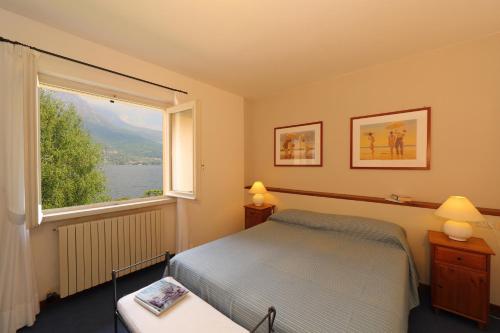 a bedroom with a bed and a large window at La Spiaggia in Oliveto Lario