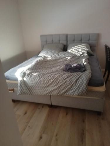 Hotel Bruchsaler Herz في بروشسال: سرير في غرفة نوم مع أرضية خشبية