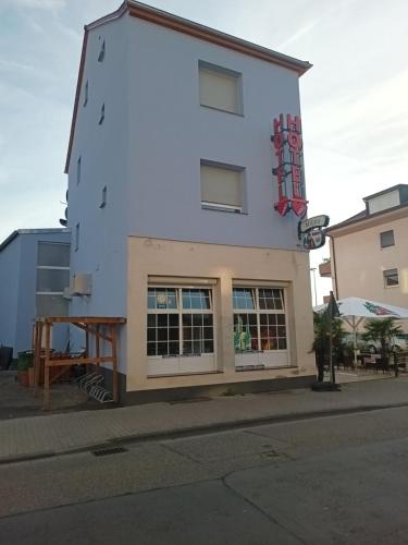 un edificio blanco alto con ventanas en una calle en Hotel Bruchsaler Herz, en Bruchsal