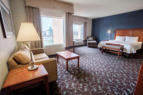 Hampton Inn & Suites Chicago Deer Park في Deer Park: غرفه فندقيه بسرير واريكه