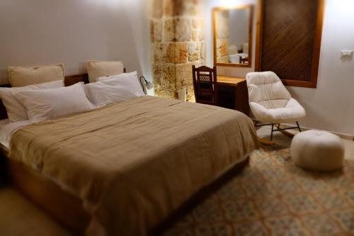 a bedroom with a bed and a desk and a chair at Pure Vida in ‘Akko