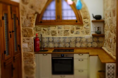 a kitchen with a stove and a window at Pure Vida in ‘Akko