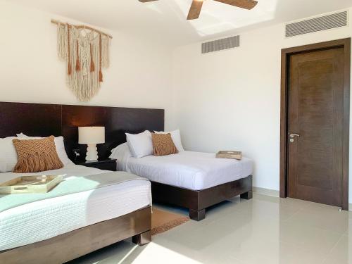 1 dormitorio con 2 camas y puerta de madera en Brand New and Amazing Penthouse! en Playa del Carmen