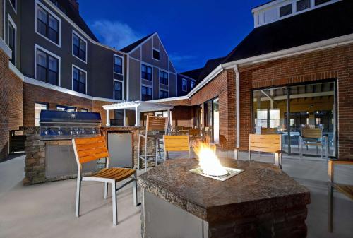 a patio with a fire pit and chairs and a building at Homewood Suites by Hilton Chicago-Lincolnshire in Lincolnshire