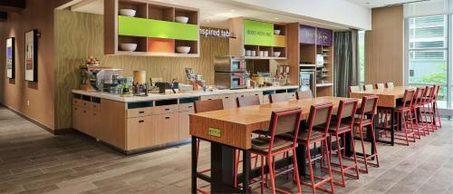 um restaurante com um bar com mesas e cadeiras de madeira em Home2 Suites By Hilton Chicago McCormick Place em Chicago