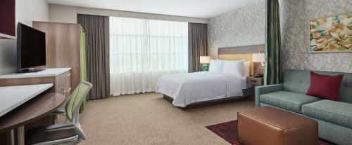Habitación de hotel con cama y sofá en Home2 Suites By Hilton Chicago McCormick Place, en Chicago