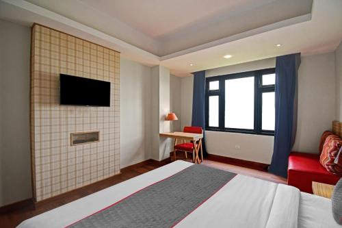 a bedroom with a bed and a tv on a wall at Super Townhouse Mansarovar Hotel in Gangtok
