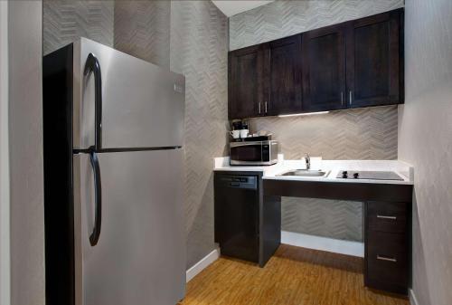 a kitchen with a white refrigerator and a sink at Homewood Suites by Hilton Chicago-Lincolnshire in Lincolnshire