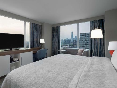 um quarto de hotel com uma cama grande e uma janela grande em Hampton Inn Chicago McCormick Place em Chicago