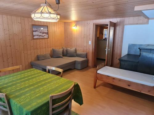 ein Wohnzimmer mit einem Sofa und einem Tisch in der Unterkunft Ferienwohnung Berner Oberland - Guttannen in Guttannen