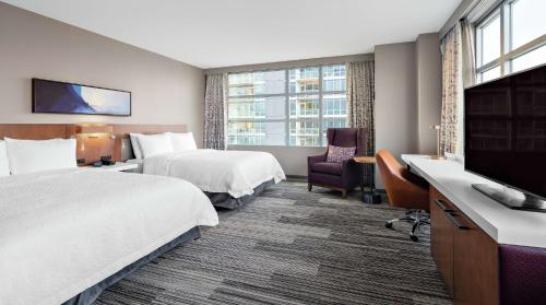 a hotel room with two beds and a flat screen tv at Hilton Garden Inn Chicago McCormick Place in Chicago