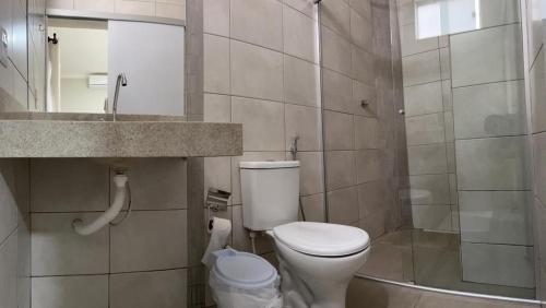 a bathroom with a white toilet and a sink at Grande Hotel in Gurupi