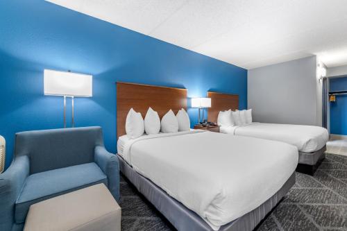 a hotel room with two beds and a blue wall at Best Western Bloomington Edina - Minneapolis in Bloomington