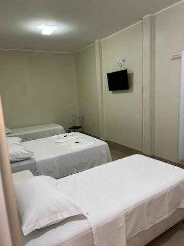 a hospital room with two beds and a television at Grande Hotel in Gurupi