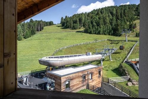 a gondola on a hill with a train on it at Berghotel Schlemmer in Bressanone