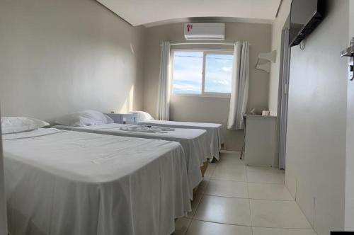 a hospital room with two beds and a window at Grande Hotel in Gurupi