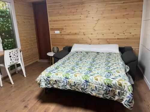1 dormitorio con 1 cama y pared de madera en Apartamento de un dormitorio con jardin, en Gandía