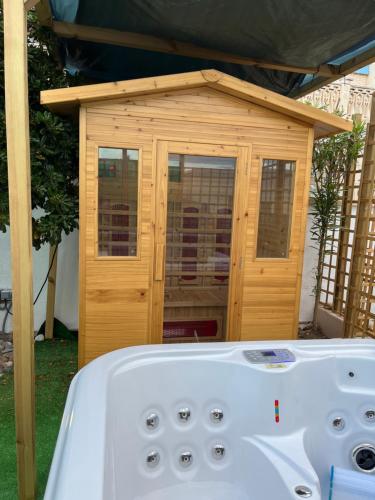 a bath tub sitting in front of a wooden dog house at Apartamento de un dormitorio con jardin in Gandía