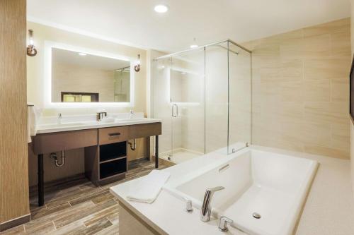 a bathroom with a tub and a sink and a shower at Homewood Suites By Hilton Charleston Historic District in Charleston